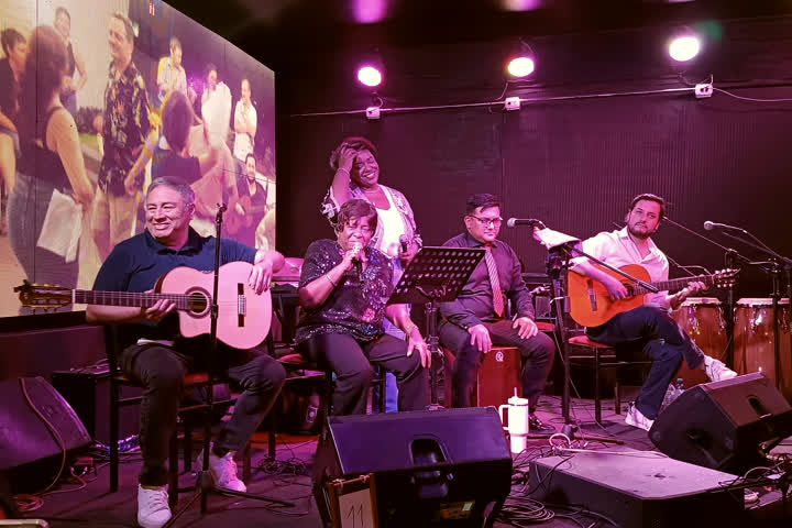 Rosita Guzmán en escena junto a su ensamble de guitarras y percusión.